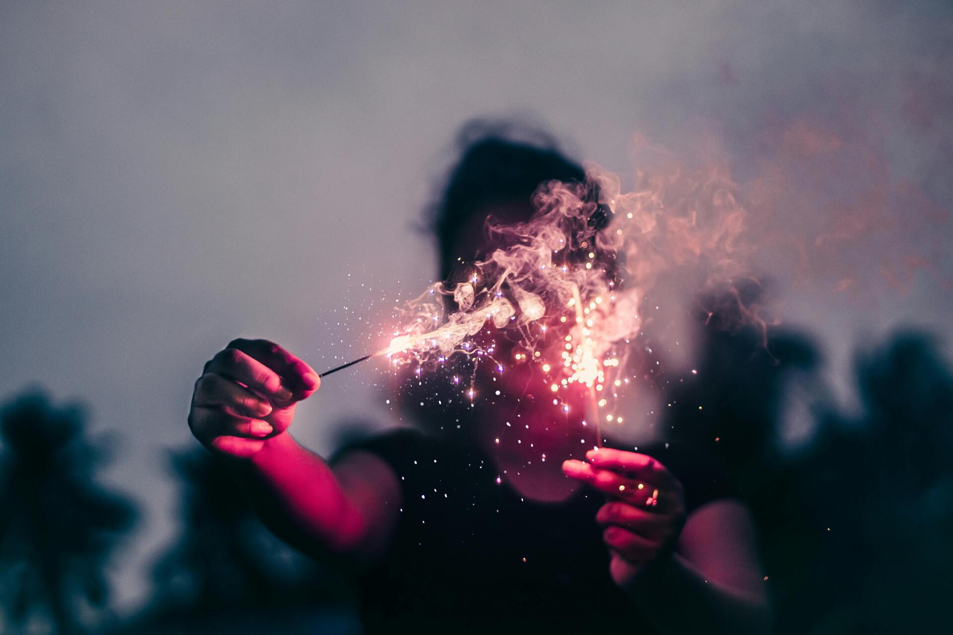 Person holding sparklers in the dark