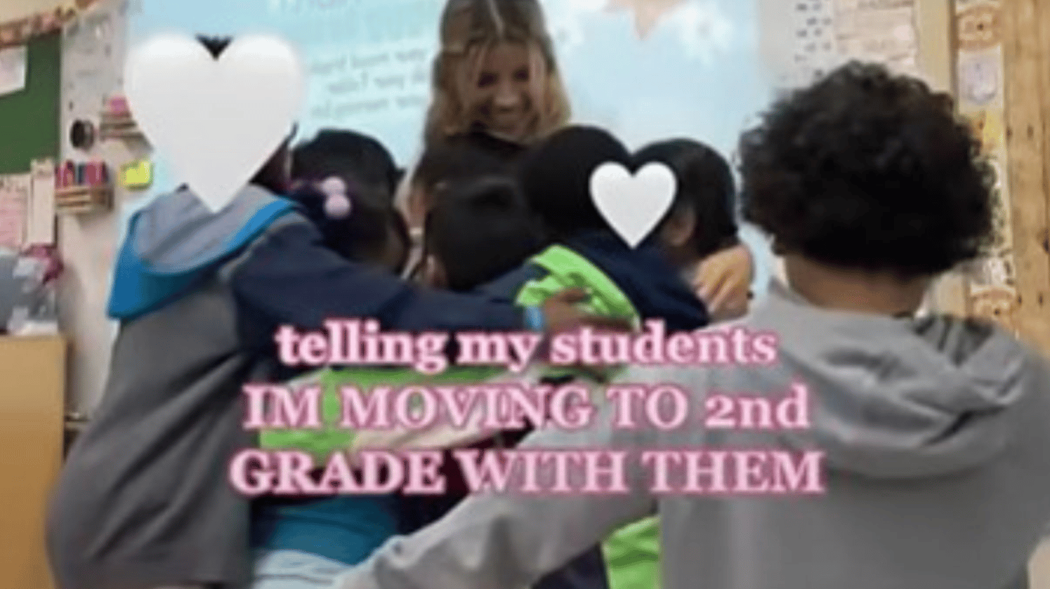Students get a group hug after their teacher tells them she's moving to second grade with them.