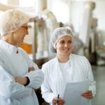 Two Young Gorgeous Female Workers Are Having A Chat While One Of