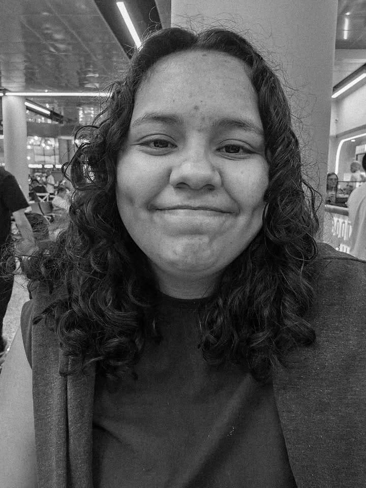 Fotografia em preto e branco da autora paraense Luana Cruz sorrindo para a camera.