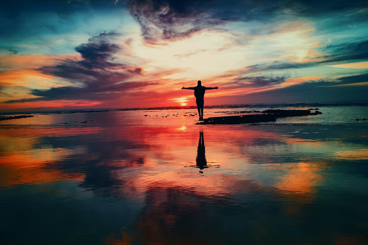 Man standing on water with sunset