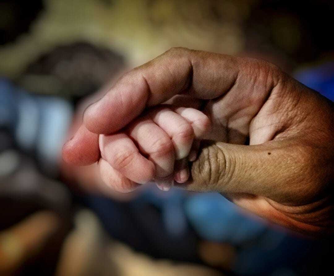 person holding babys hand
