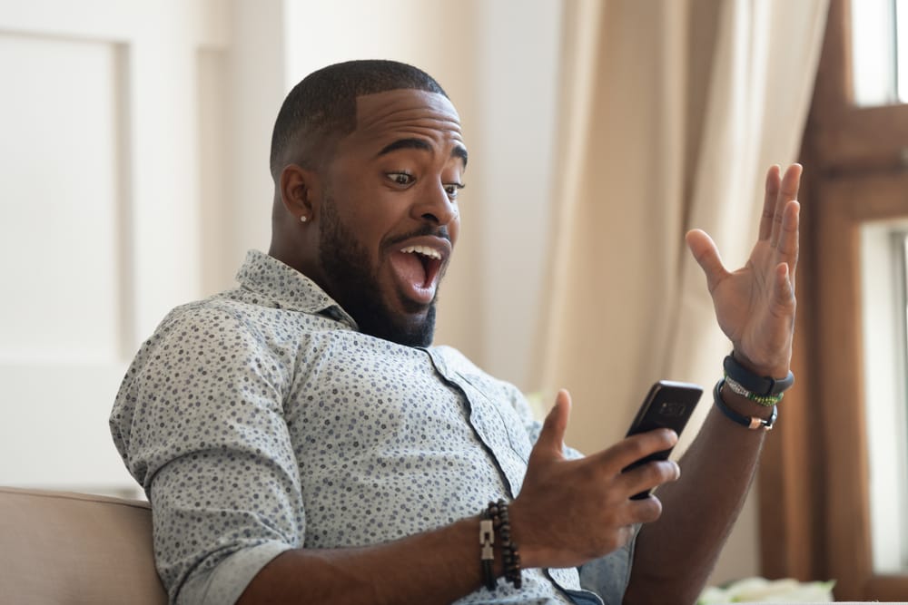 surprised happy man holding cell phone vervology 2