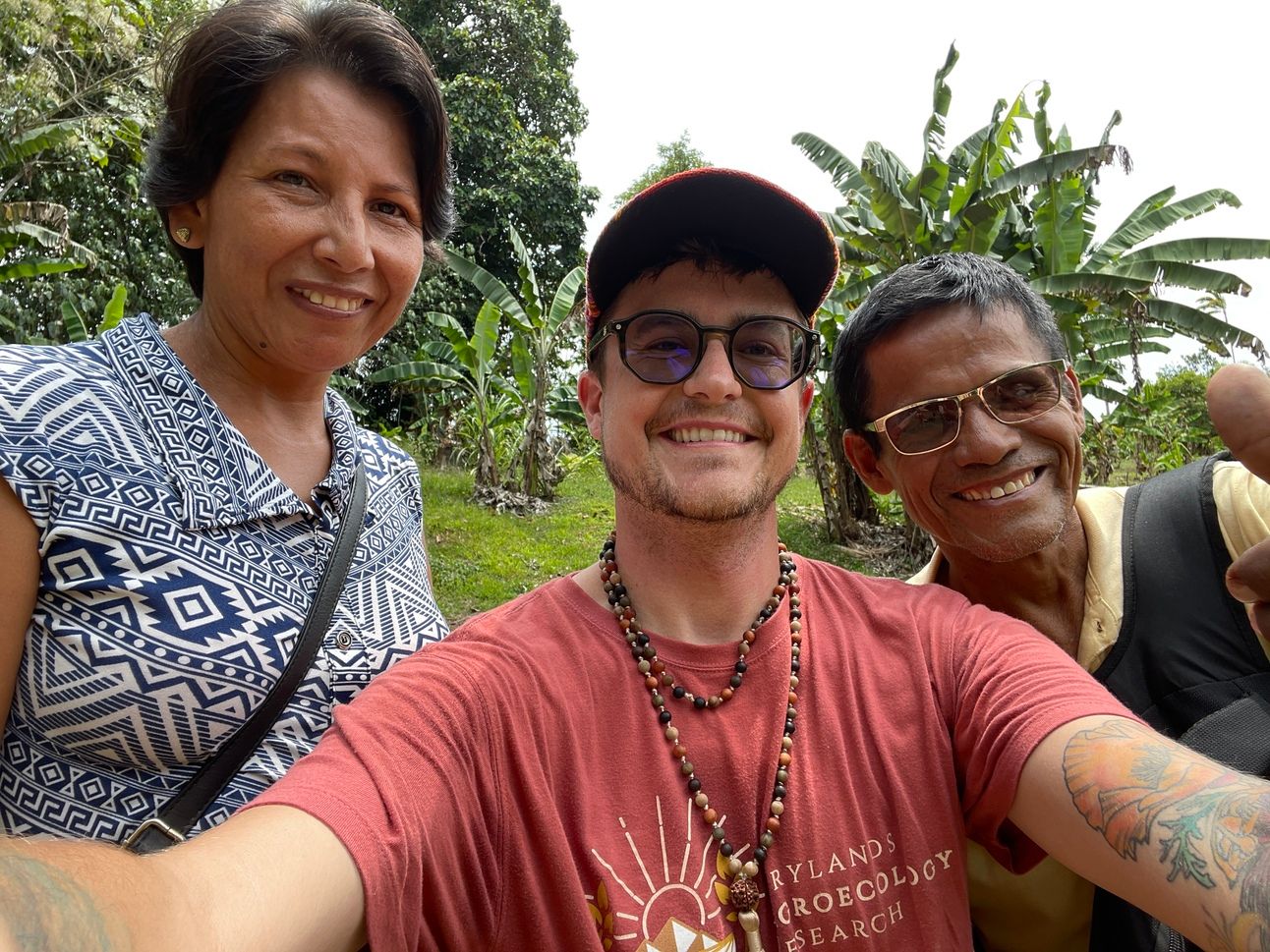 Three people stand together smilig for a selfie.