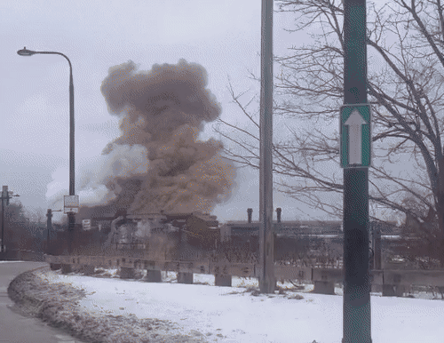 a large plume of steam coming from a steel factory