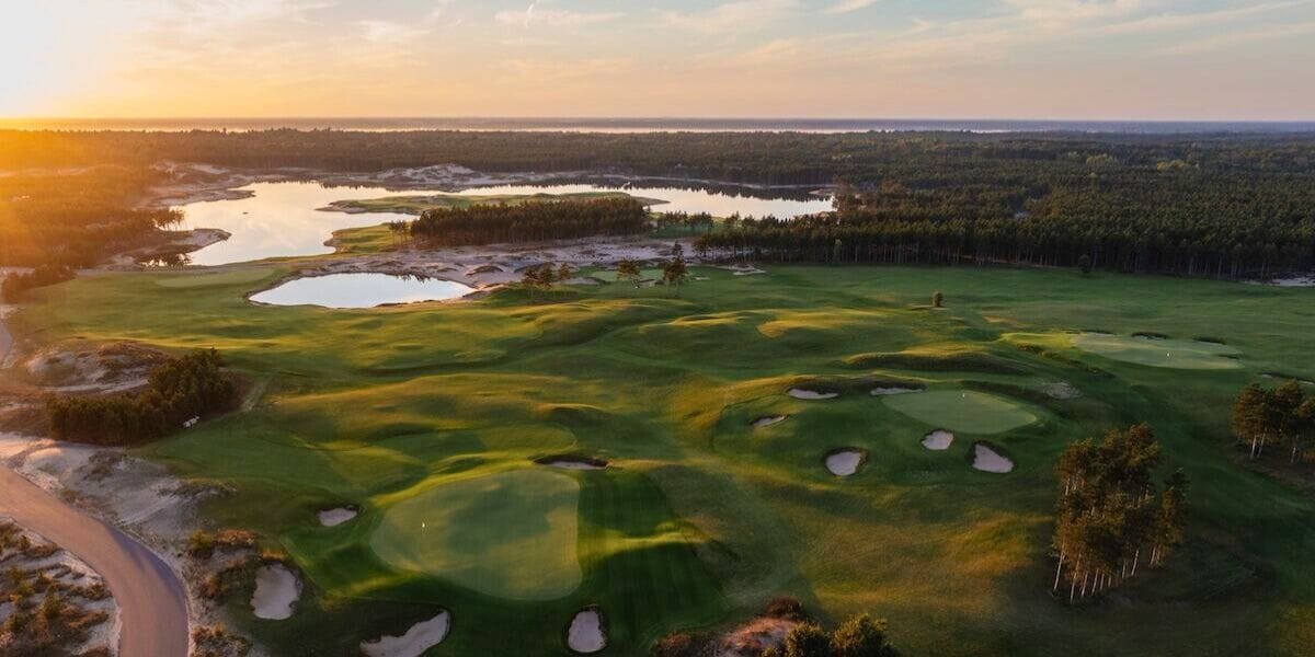 the sun rises over a golf course