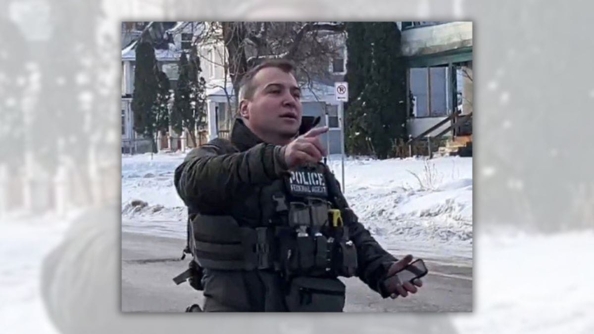An image allegedly shows a man wearing a police vest while standing outside in a neighborhood covered with snow. 