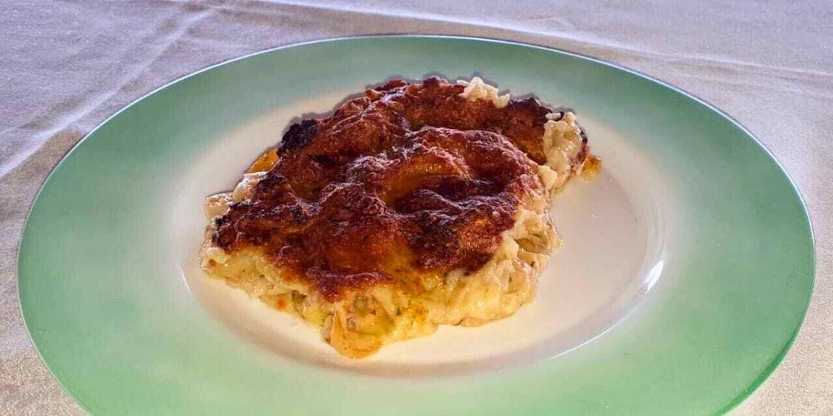 Baked dish of Sardinian zuppa gallurese with layers of bread and melted cheesee