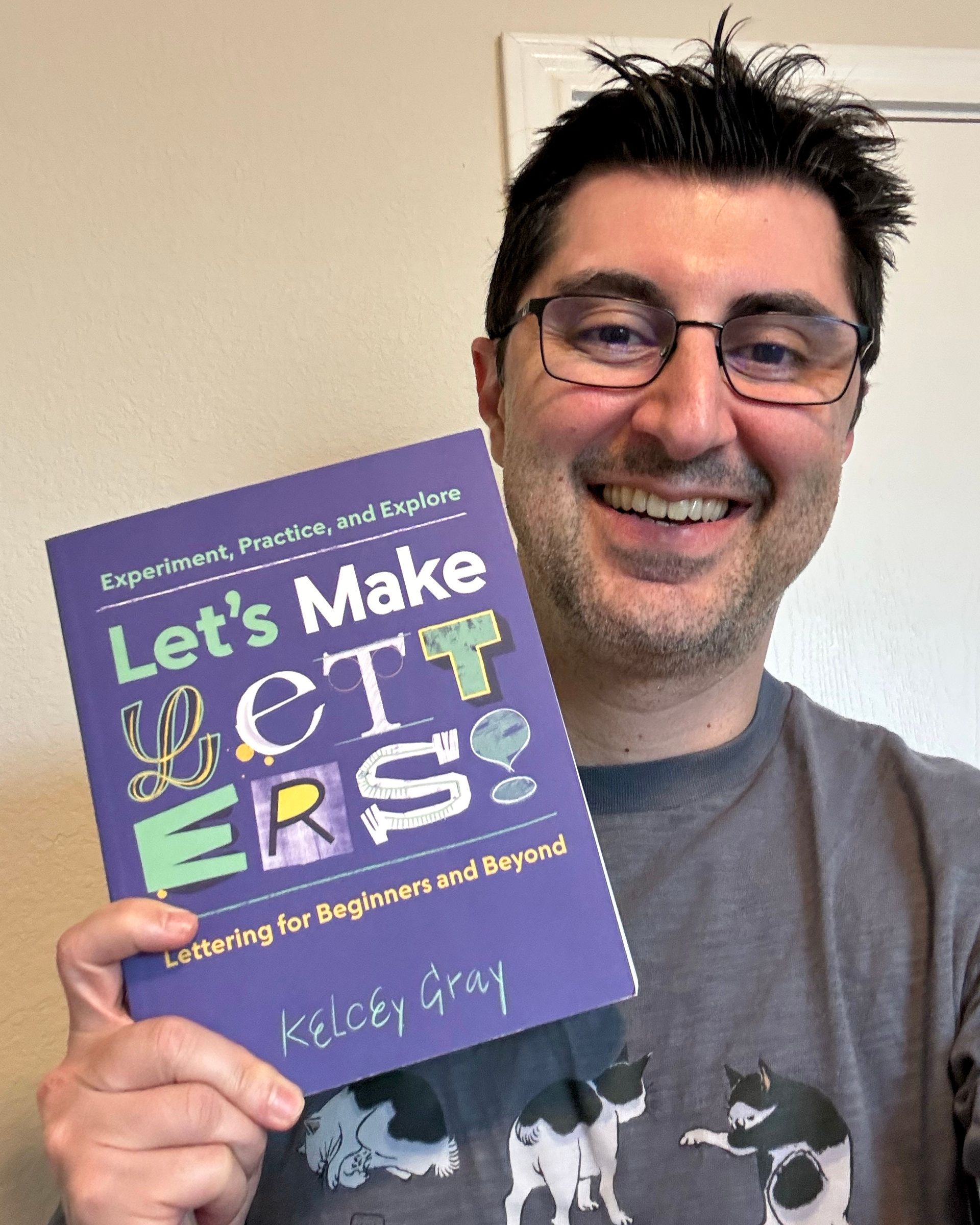 PJ Milani holds up the book, Let's Make Letters by Kelcey Gray