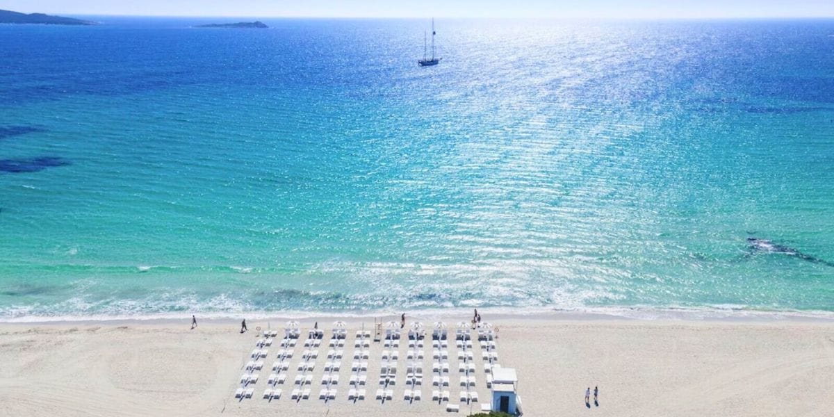 Private beach with loungers and umbrellas at Baglioni Resort, looking out over crystal-clear turquoise water