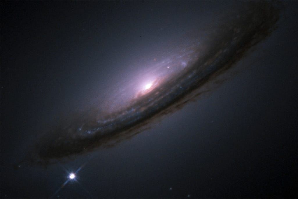 The bright dot of Supernova 1994D appears next to galaxy NGC 4526. 