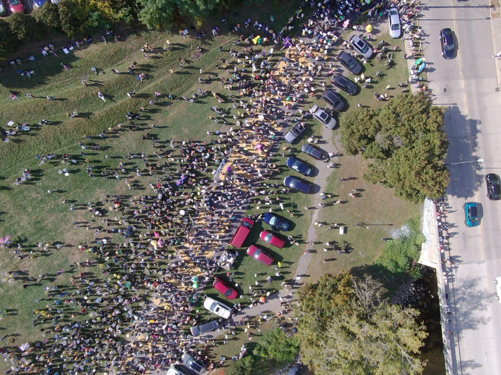 Aerial view. Thousands of people fill Riverside Park as marchers file onto the sidewalk.