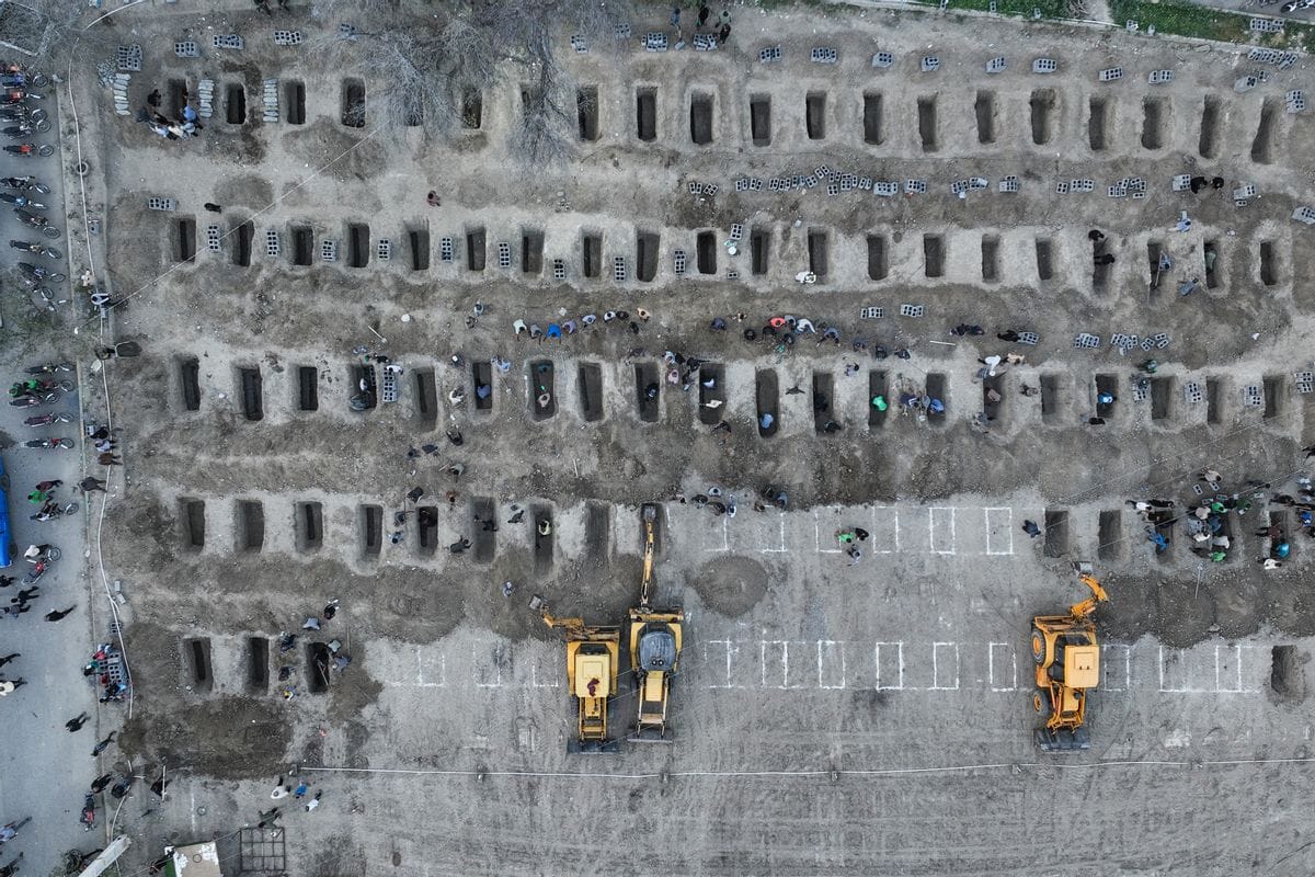 In this image, mourners dig graves during the funeral for children killed in a reported strike on a primary school.
