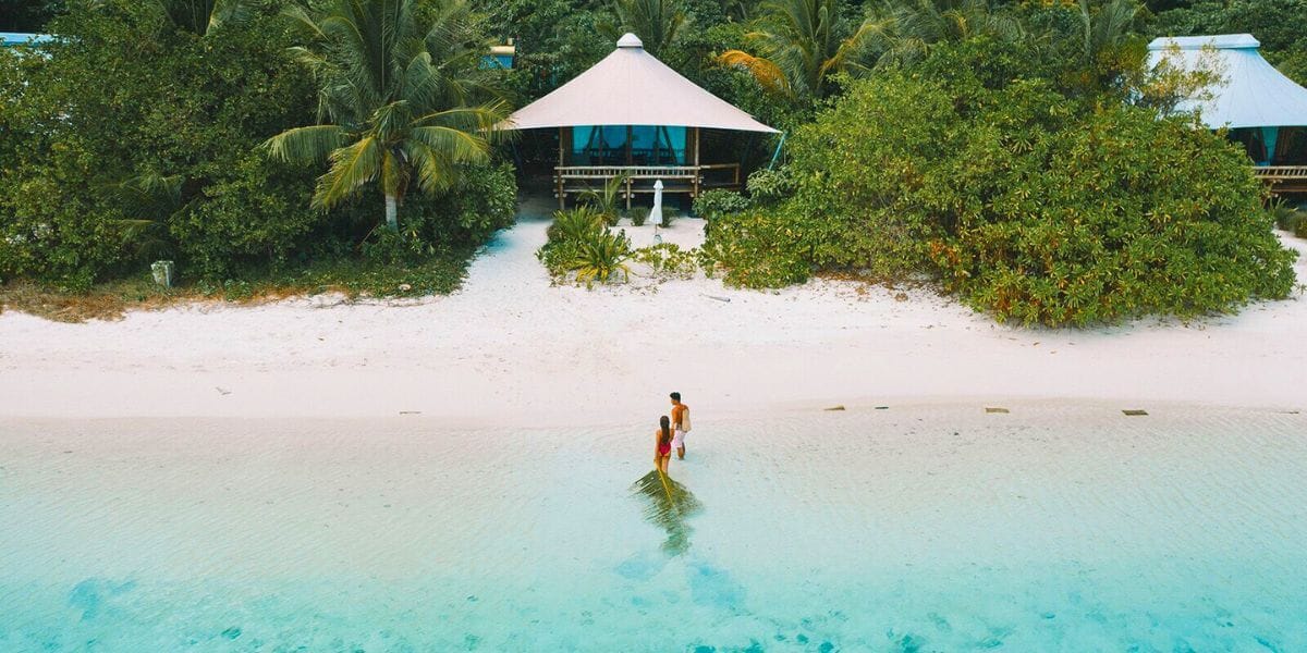 a couple walking into their hut