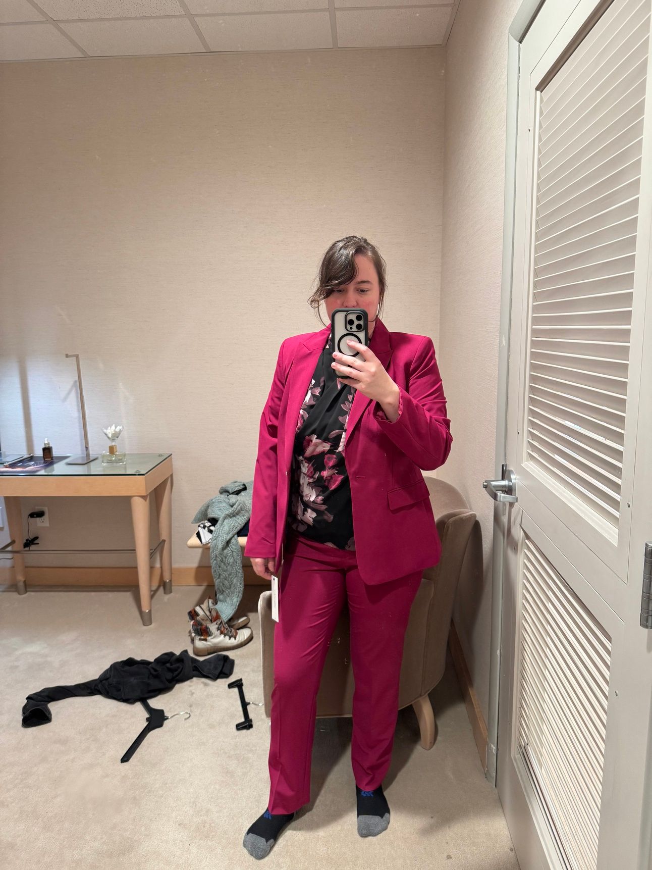 photo of a femine body in a pink suit blazer and pants with a black and pink floral top.