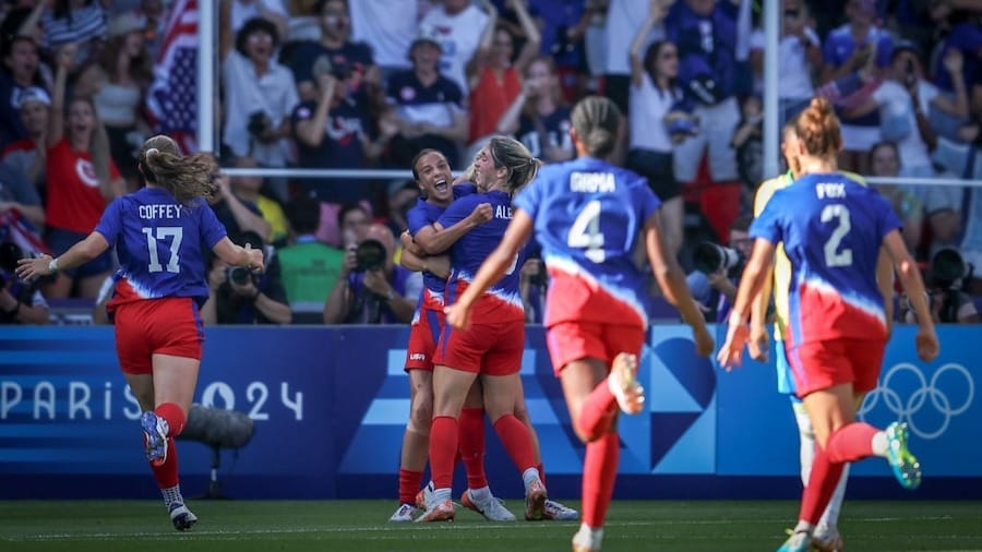 Mallory Swanson of the United States team is celebrating with a teammate after scoring the first goal during the Women's Gold Medal match.
