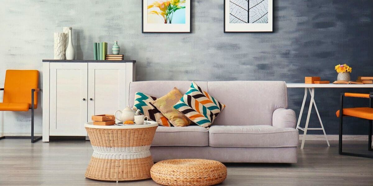 a living room with a couch pillows and tables