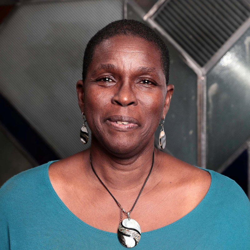 Photo of Sharon Hurley Hall, Founder, Sharon's Anti-Racism Newsletter. Sharon, a dark-skinned Black woman with short natural hair is wearing a teal scoop necked top