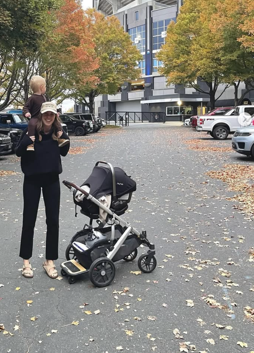 Caroline Frazier and her toddler and newborn outside of the Carolina Panther's stadium with a stroller