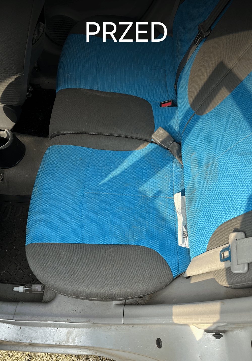 Zabrudzona tylna kanapa w Kia przed czyszczeniem – widoczne plamy i zabrudzenia na tapicerce oraz zanieczyszczenia przy podłodze, Chełmno, kujawsko-pomorskie