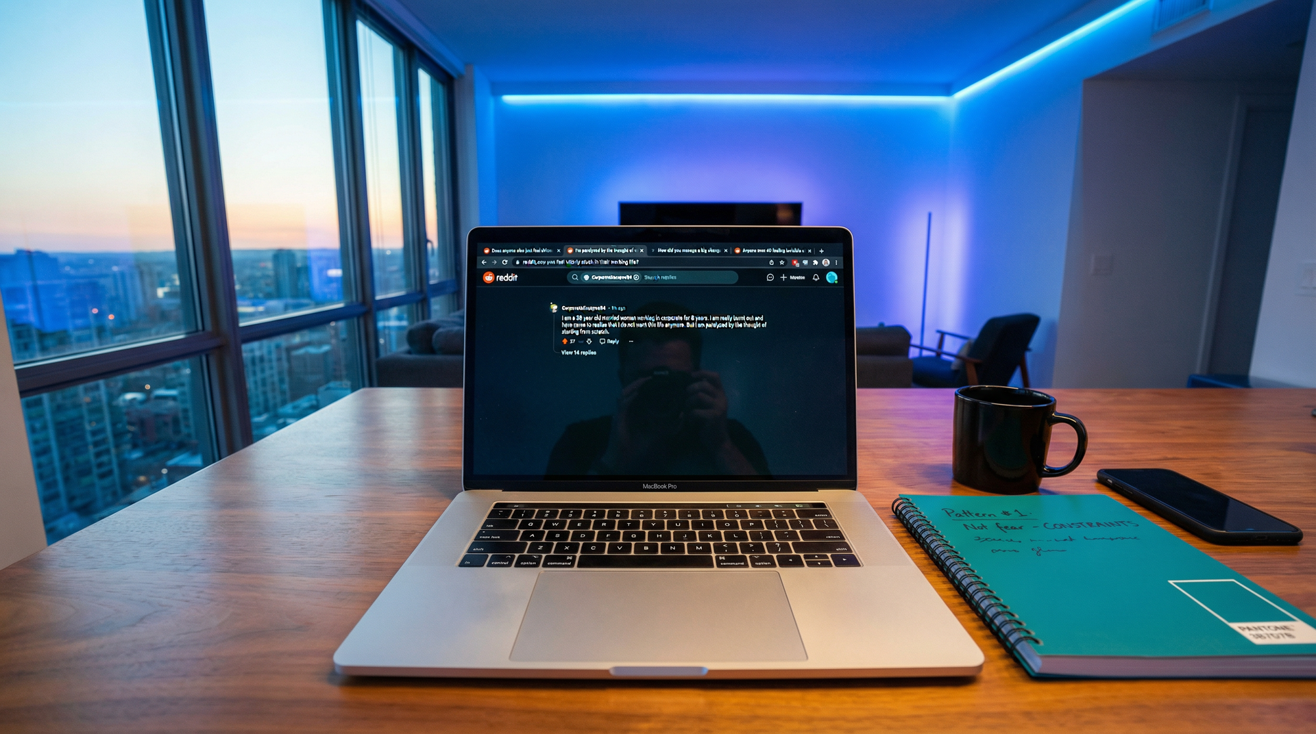 Laptop screen showing Reddit threads from women over 40 discussing feeling stuck in careers, with notebook showing research notes