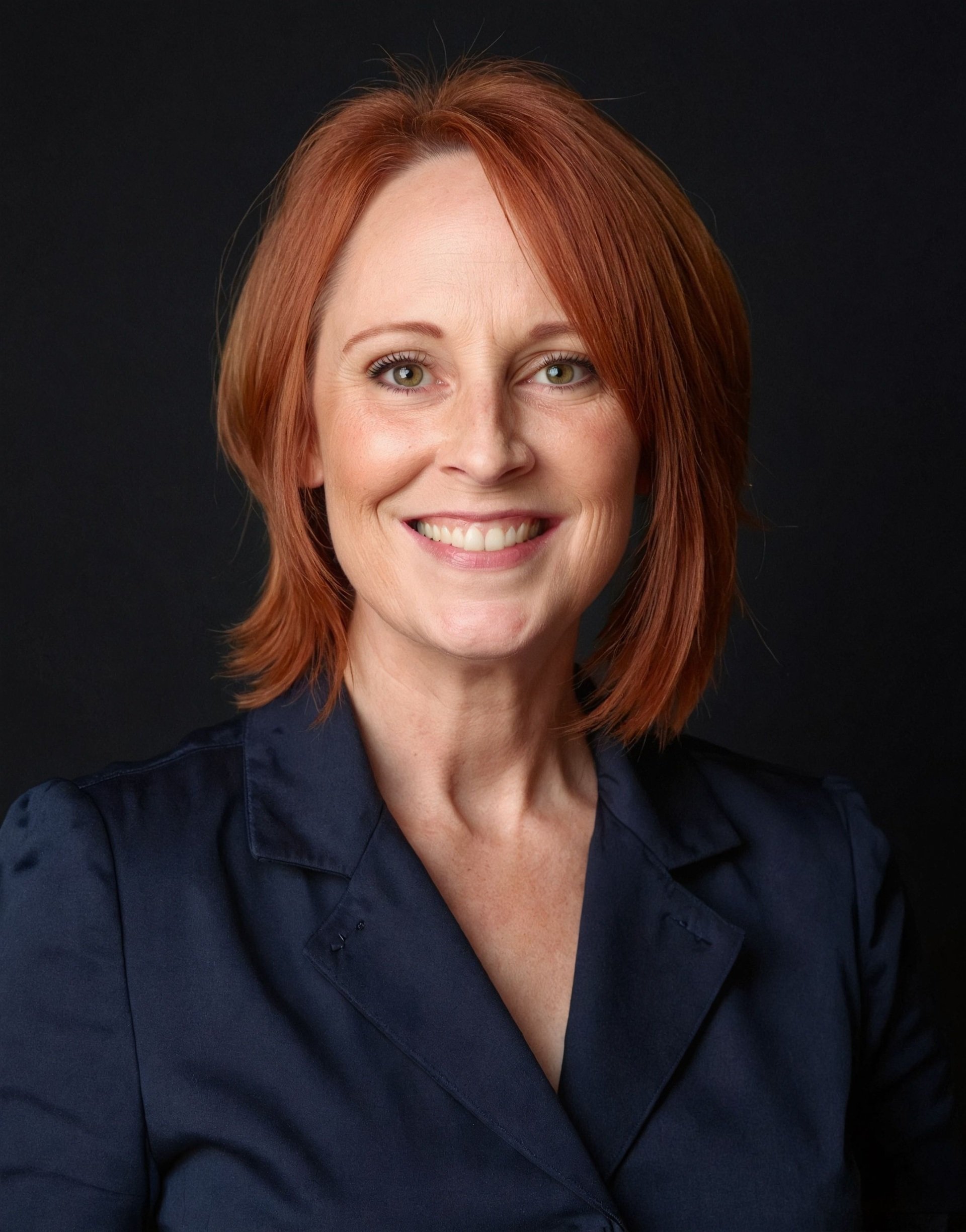Headshot of Bobbie Kay, Author of Solid Ground, smiling, with shoulder-length, straight, red hair.