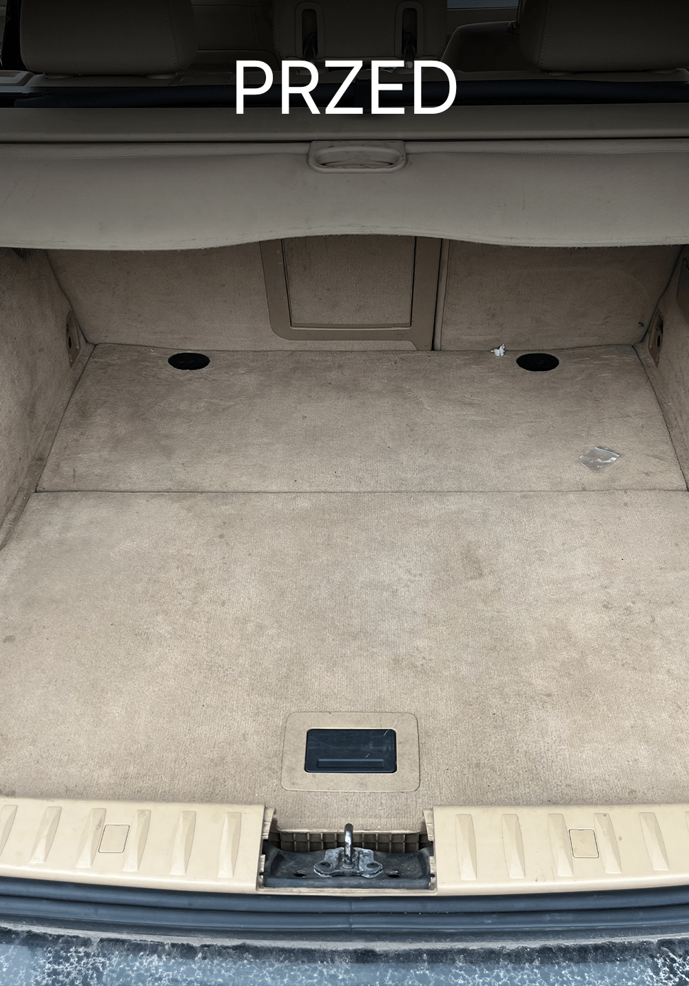Zabrudzony bagażnik w BMW przed czyszczeniem – plamy i ślady użytkowania na jasnej wykładzinie oraz zanieczyszczenia w przestrzeni ładunkowej, Chełmno, kujawsko-pomorskie