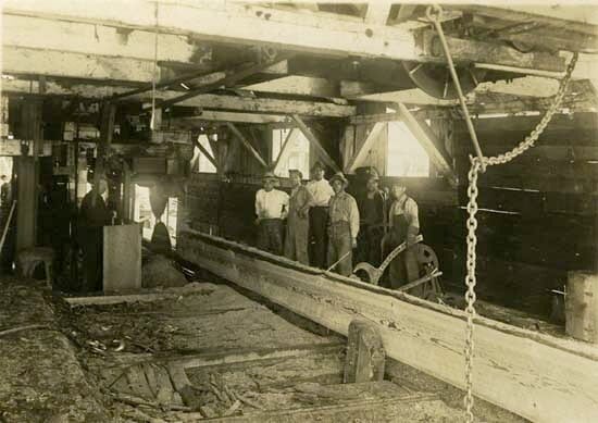 Six Chinese men inside a mill building posing for the camera, around 1920. / New Westminster Museum and Archives IHP8534