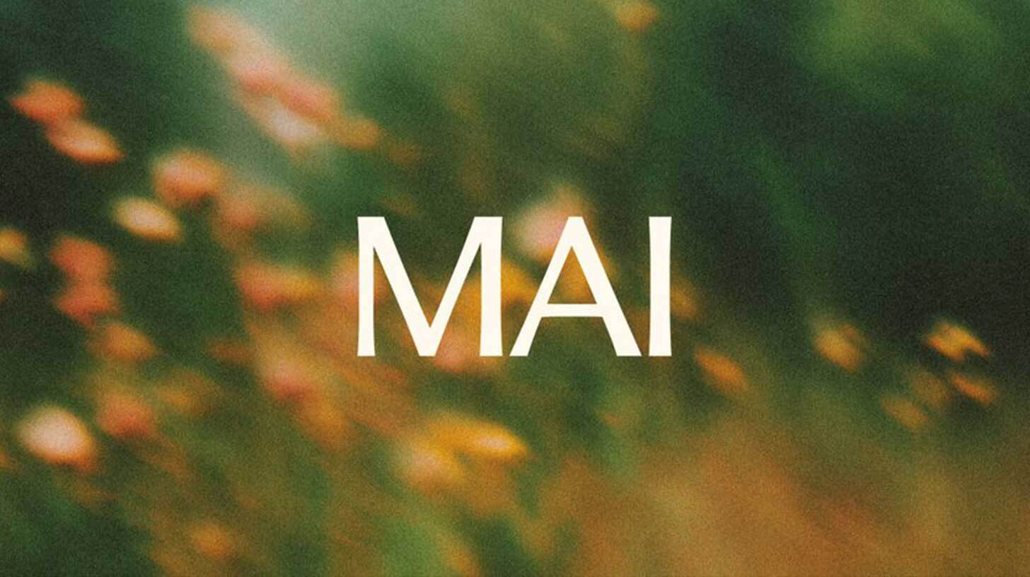 Udune pilt värvilistest lilledest rohelisel taustal, mille keskel on suurte tähtedega sõna 'MAI'.